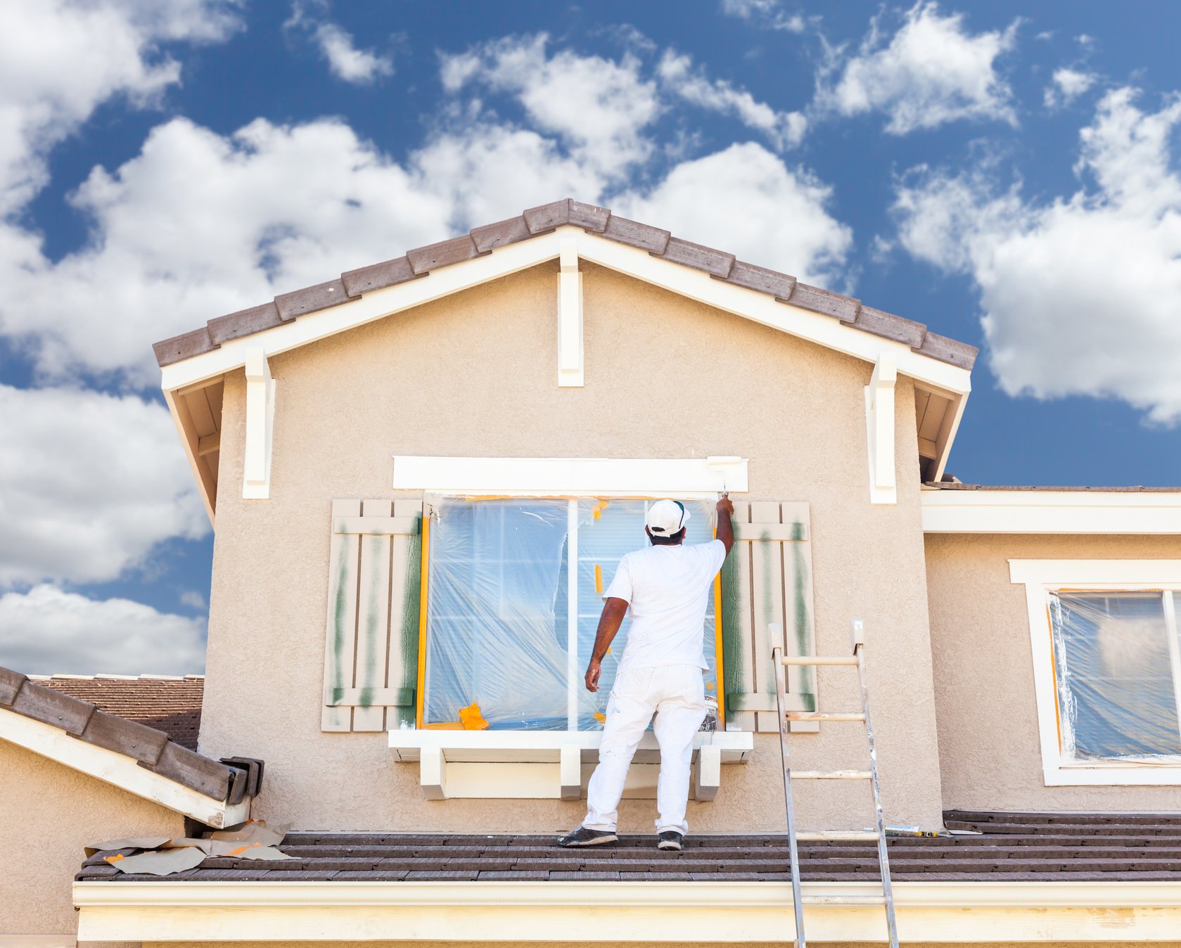 Professional House Painter Painting The Trim And Shutters